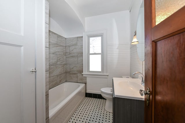 bathroom with vanity, toilet, and a bath