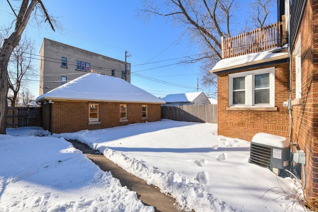 snow covered rear of property with central air condition unit