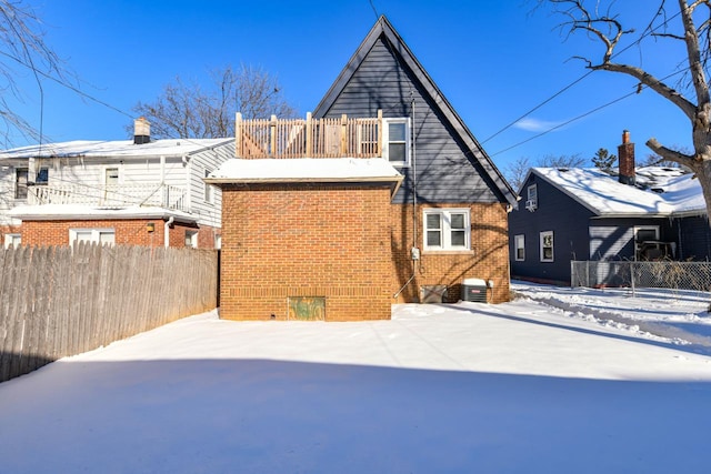 snow covered property featuring central air condition unit and a balcony