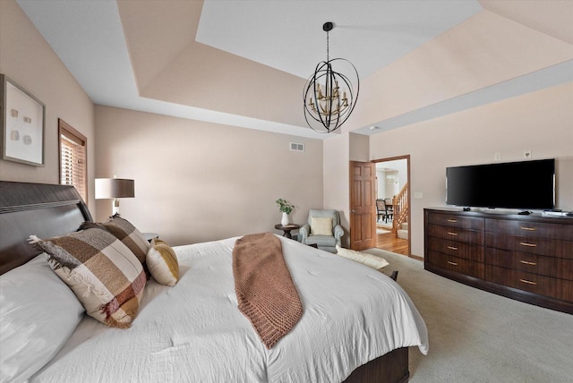 carpeted bedroom with a chandelier, a raised ceiling, and visible vents