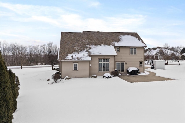 view of snow covered back of property