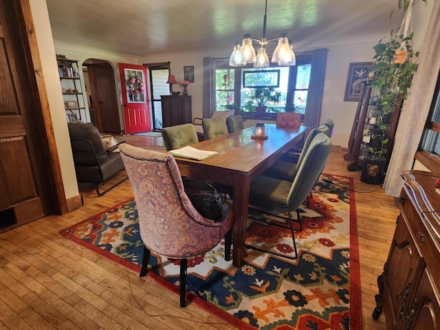 dining area featuring light wood-type flooring and a notable chandelier