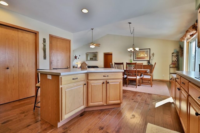 kitchen featuring hanging light fixtures, lofted ceiling, dark wood-type flooring, and a kitchen island