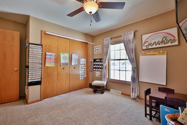 living area with ceiling fan and light carpet