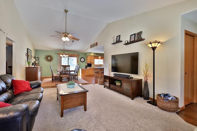 living room with high vaulted ceiling, ceiling fan, and light colored carpet