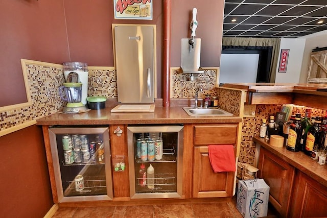 bar with wine cooler, sink, and backsplash