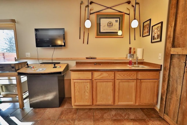 bar featuring sink and hanging light fixtures