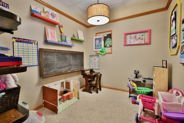 rec room featuring ornamental molding, carpet flooring, and a drop ceiling