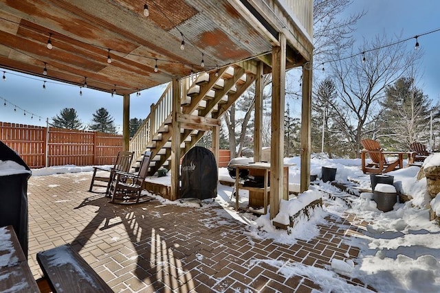 snow covered patio featuring a grill