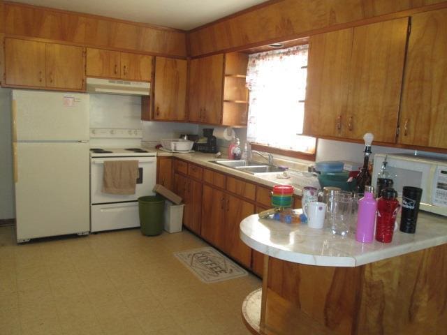 kitchen featuring sink, white appliances, and kitchen peninsula