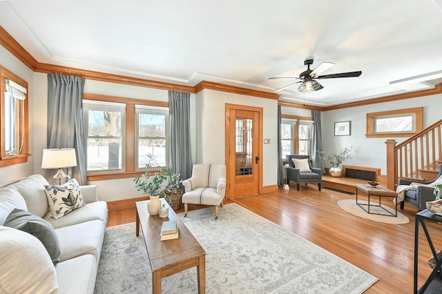 living room with light hardwood / wood-style flooring, ceiling fan, and ornamental molding