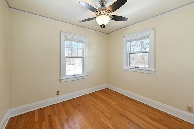 unfurnished room with hardwood / wood-style floors, ceiling fan, a wealth of natural light, and crown molding