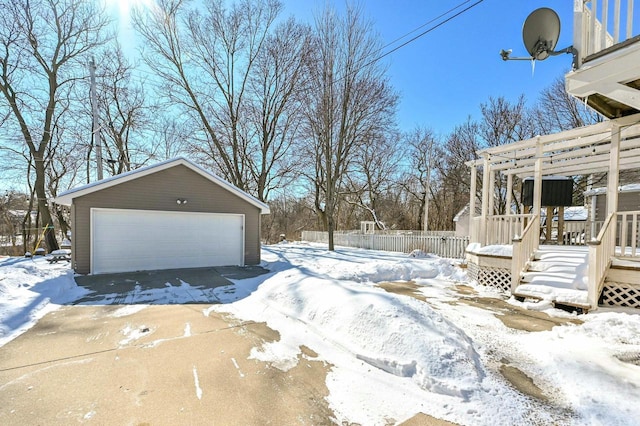 yard layered in snow with an outdoor structure and a garage