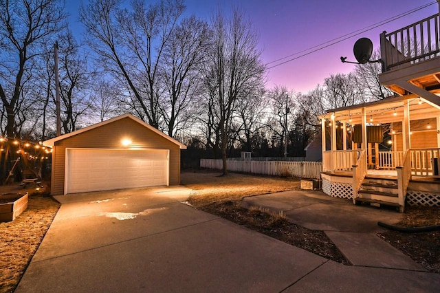 yard at dusk featuring an outbuilding, a garage, and a wooden deck