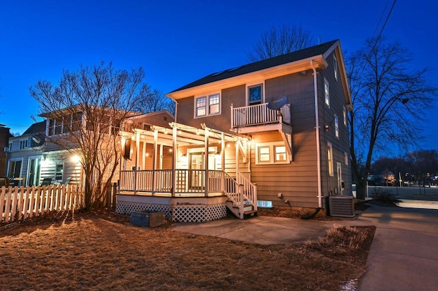 back of property with a pergola, cooling unit, and a balcony