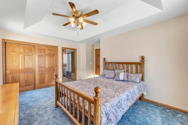 bedroom featuring ceiling fan, a raised ceiling, and carpet