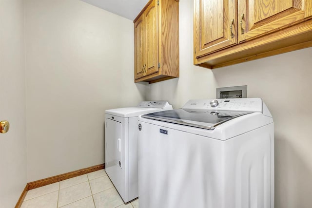 laundry area with cabinets, independent washer and dryer, and light tile patterned floors