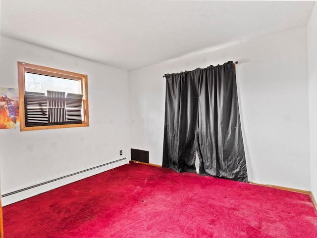 carpeted spare room with a baseboard radiator