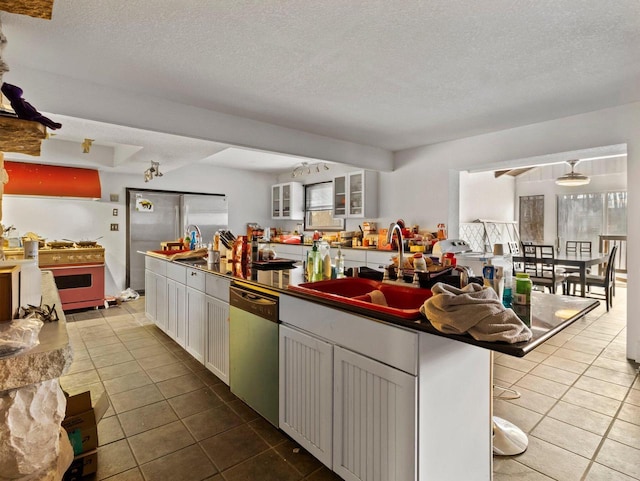 kitchen featuring sink, white cabinets, a kitchen breakfast bar, and dishwasher