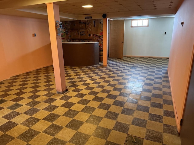 basement with a paneled ceiling