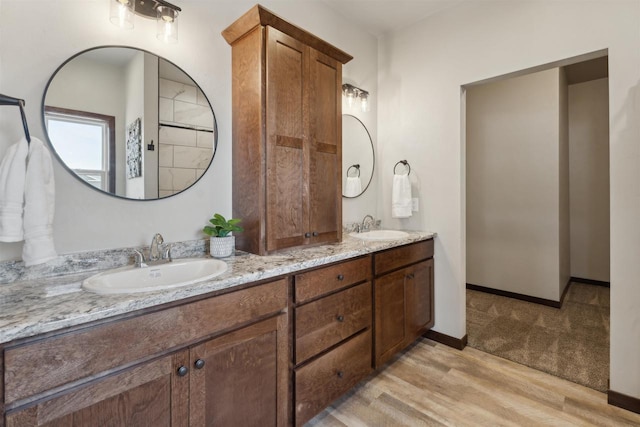 3868 E Teton Ln, Appleton, WI 54913 - bathroom with double vanity, baseboards, a sink, and wood finished floors
