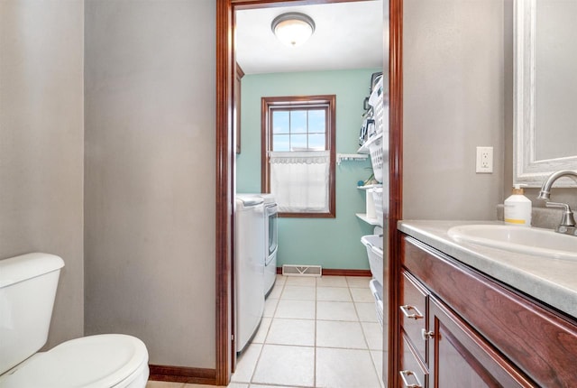 bathroom with tile patterned floors, washer and dryer, vanity, and toilet