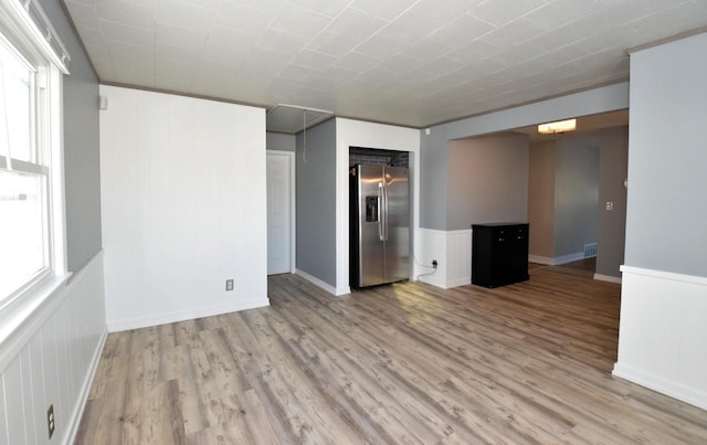 spare room featuring light hardwood / wood-style flooring and crown molding