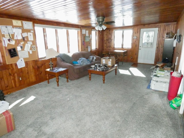 unfurnished living room with carpet, wooden ceiling, and wooden walls