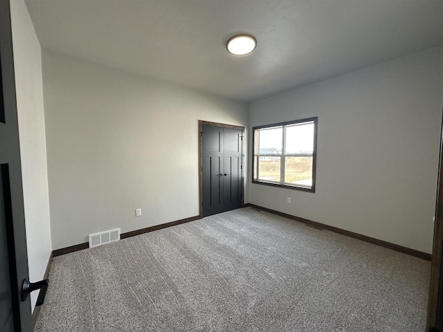 unfurnished bedroom featuring a closet, visible vents, carpet flooring, and baseboards