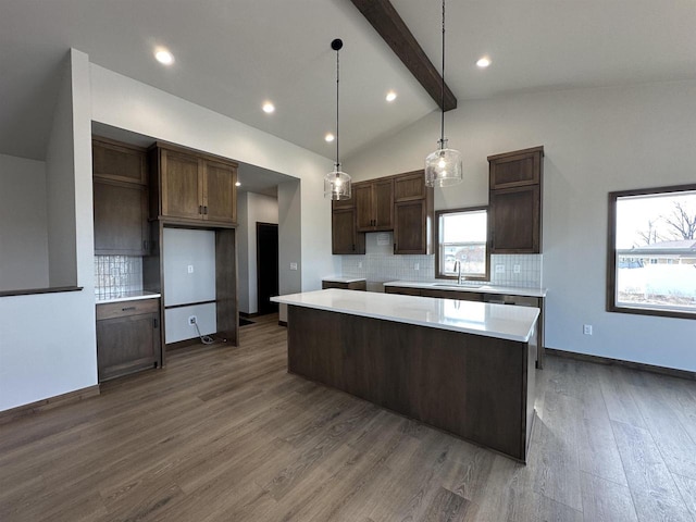 kitchen featuring dark wood finished floors, a center island, decorative backsplash, dark brown cabinets, and vaulted ceiling with beams