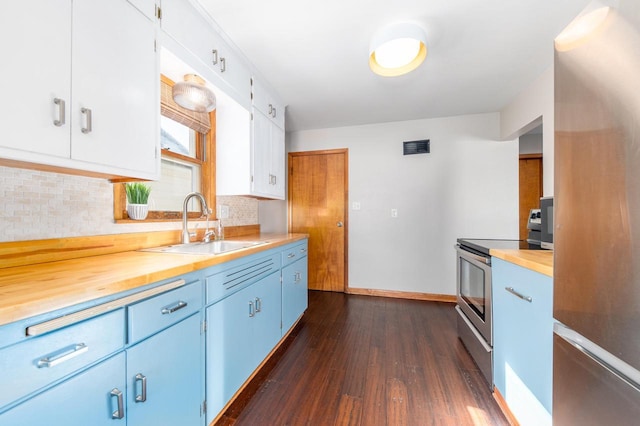 kitchen with wooden counters, stainless steel electric range oven, white cabinetry, and fridge