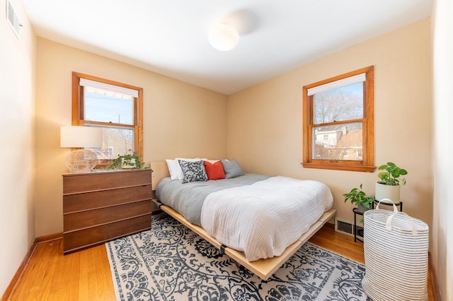 bedroom featuring multiple windows and light wood-type flooring