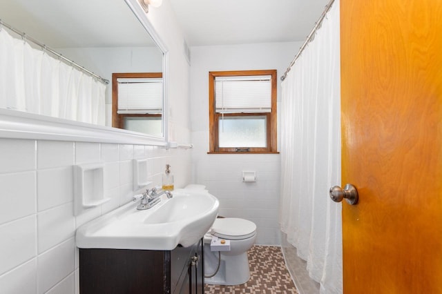 bathroom featuring tile walls, toilet, vanity, and a shower with shower curtain