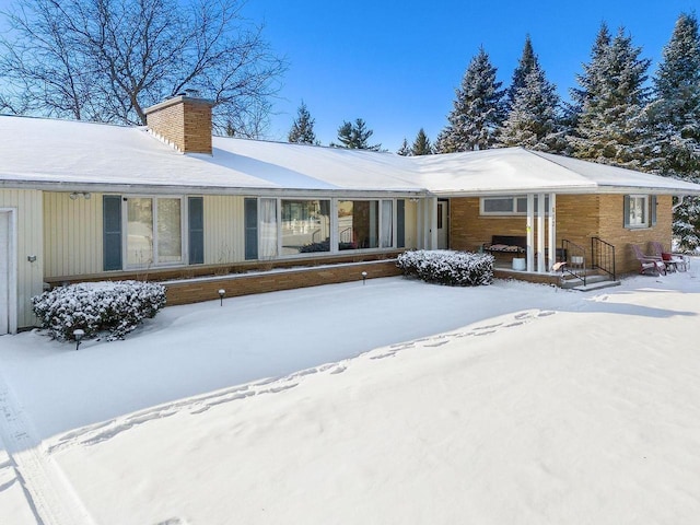 view of snow covered back of property