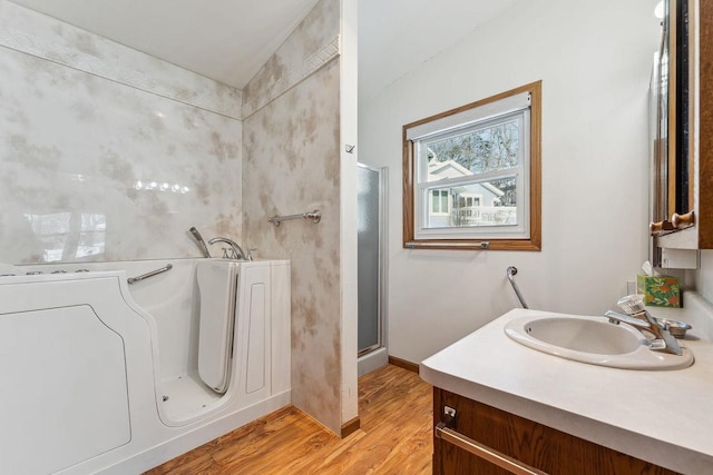 bathroom featuring hardwood / wood-style flooring, independent shower and bath, and vanity