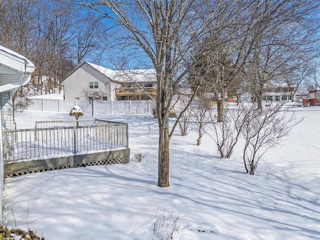 yard covered in snow with a deck