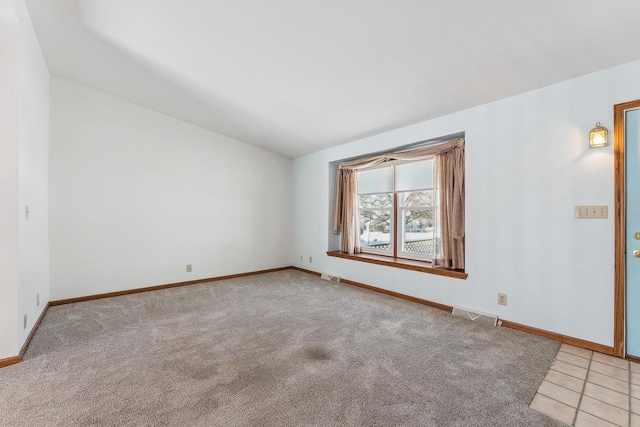 unfurnished room with lofted ceiling and light colored carpet