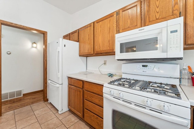 kitchen with white appliances and light tile patterned floors