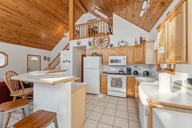 kitchen featuring white appliances, sink, a breakfast bar area, light brown cabinetry, and wood ceiling