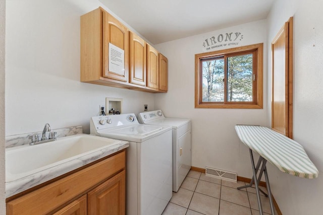 laundry room featuring cabinets, light tile patterned floors, sink, and independent washer and dryer