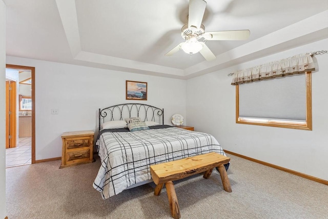 bedroom with ceiling fan, carpet flooring, and a raised ceiling