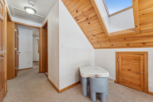 interior space featuring lofted ceiling with skylight and light colored carpet