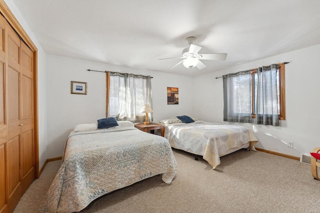 bedroom with multiple windows, a closet, ceiling fan, and carpet flooring