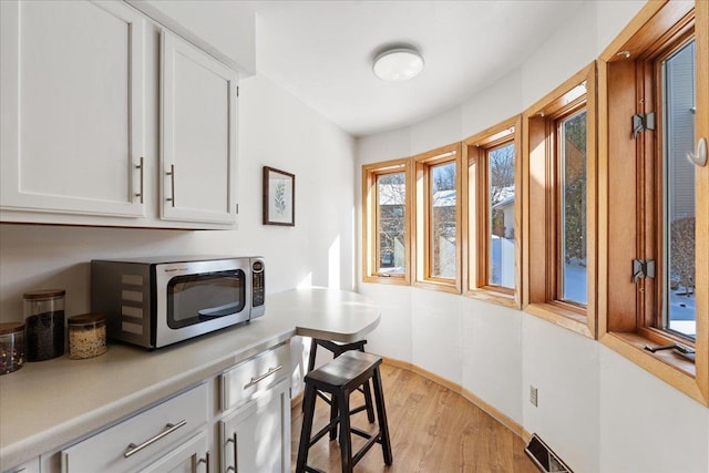 interior space featuring light wood-type flooring and white cabinetry