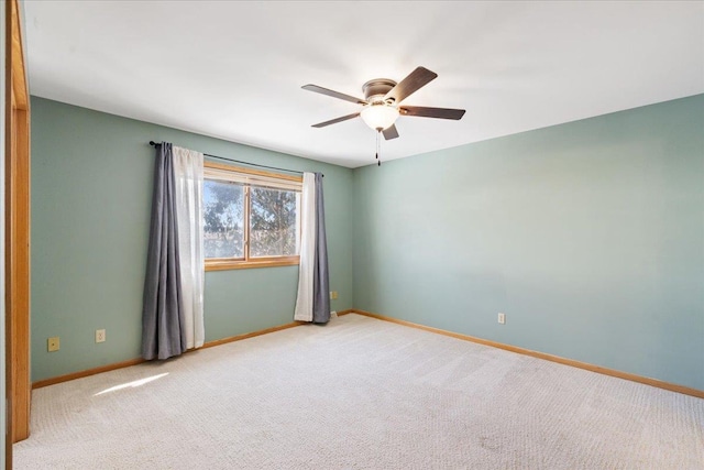 empty room with ceiling fan and light carpet