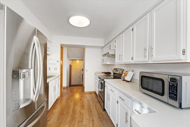 kitchen featuring light wood-type flooring, stainless steel appliances, and white cabinets