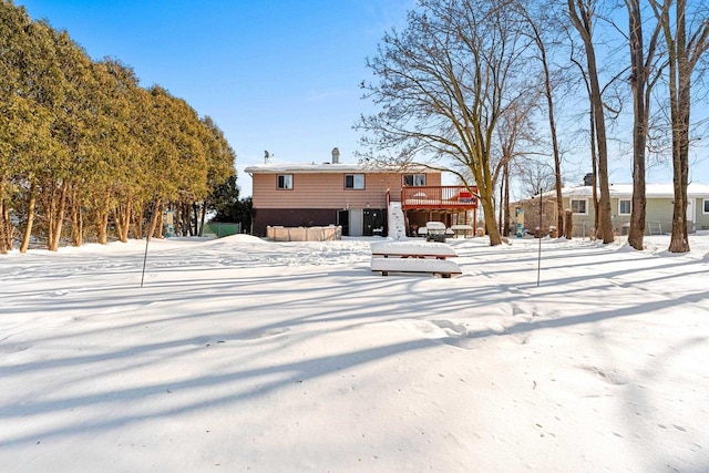 snow covered house with a wooden deck