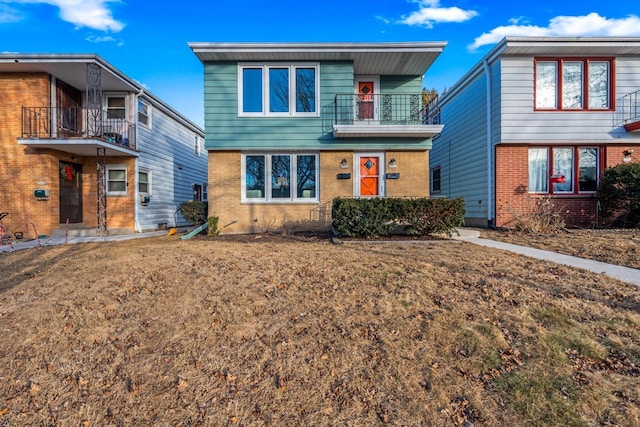 view of front of property with a balcony and a front lawn