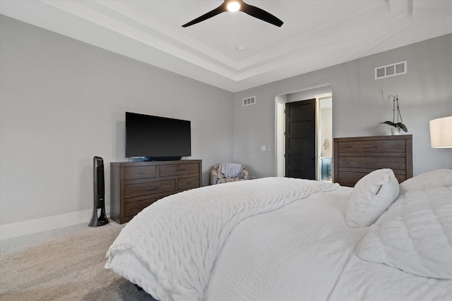 carpeted bedroom featuring ceiling fan and a tray ceiling