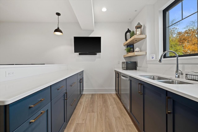 kitchen with light hardwood / wood-style flooring, hanging light fixtures, blue cabinetry, dishwasher, and sink